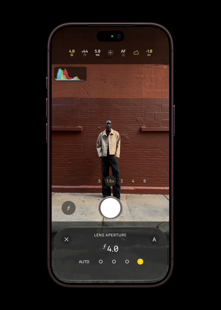 App Fotocamera di iPhone 18 Pro: il controllo dell'apertura dell'obiettivo impostato su f/4.0, con un uomo in piedi davanti a un muro di mattoni rossi
